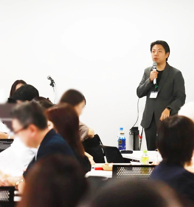 セミナー会場で登壇者が話し、参加者が聴講している様子