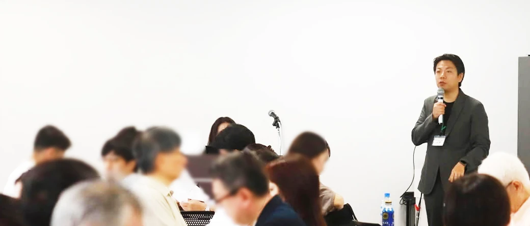 セミナー会場で登壇者が話し、参加者が聴講している様子